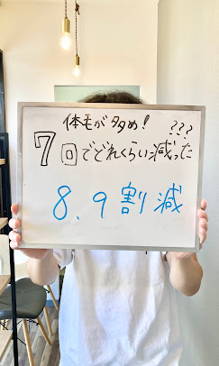 体毛が多めで7回の施術後に8、9割減と書かれたボードを持つ男性